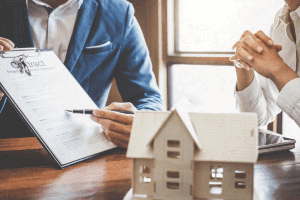 Agente inmobiliario enseñando contrato a posible cliente